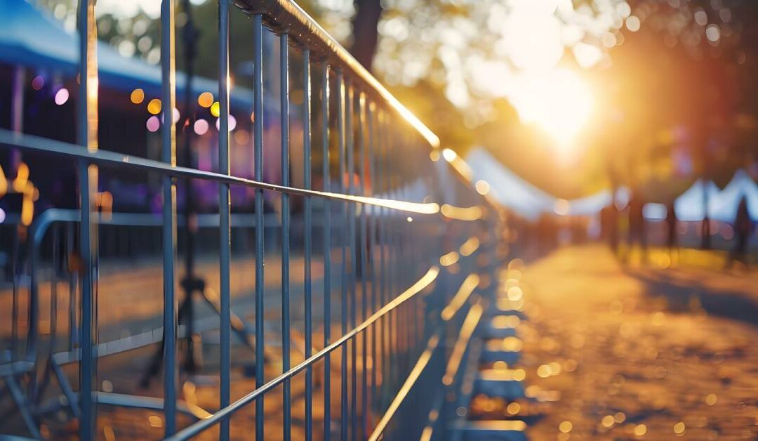 A crowd control barrier at an outdoor event. It protects electrical equipment and separates the event into two sides.